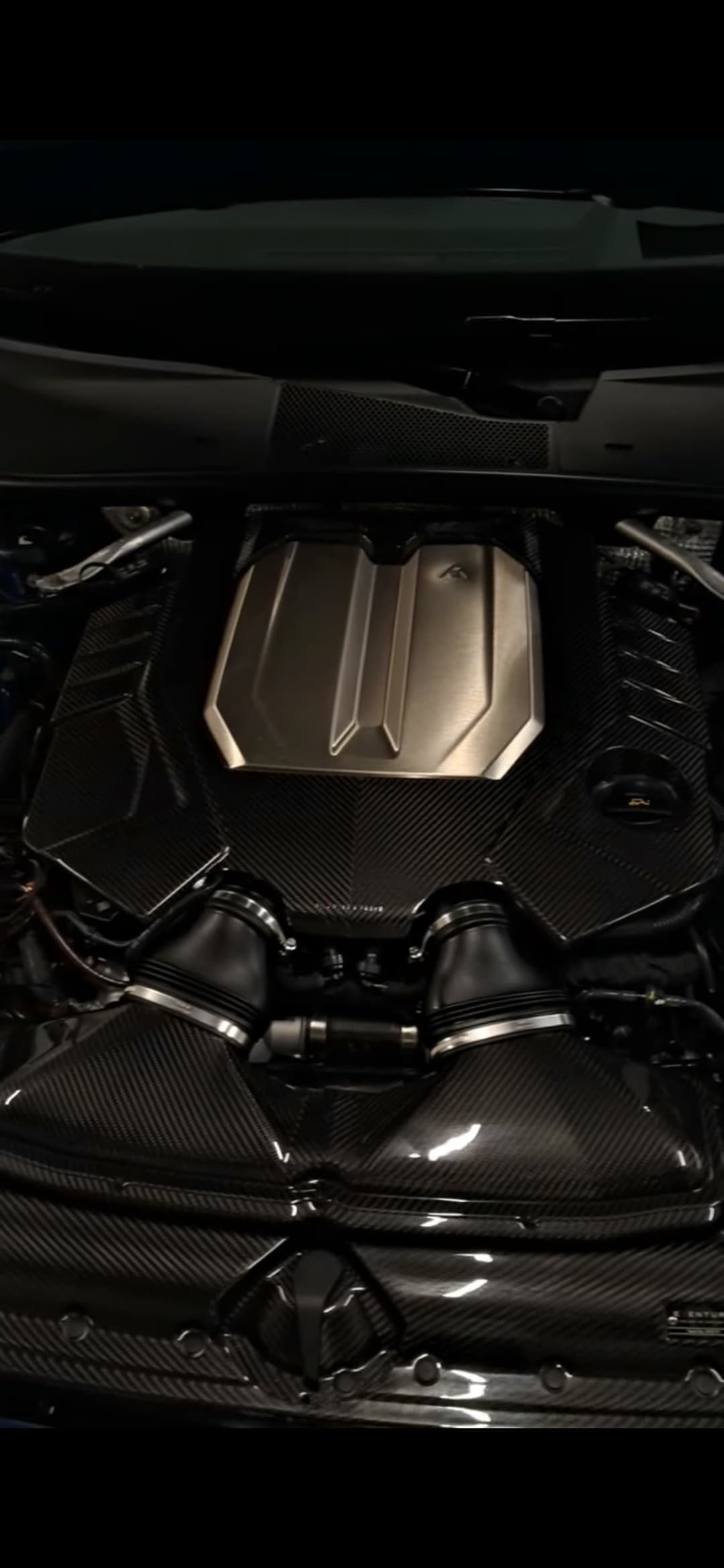 Bentley engine bay carbon fiber detail, angled view