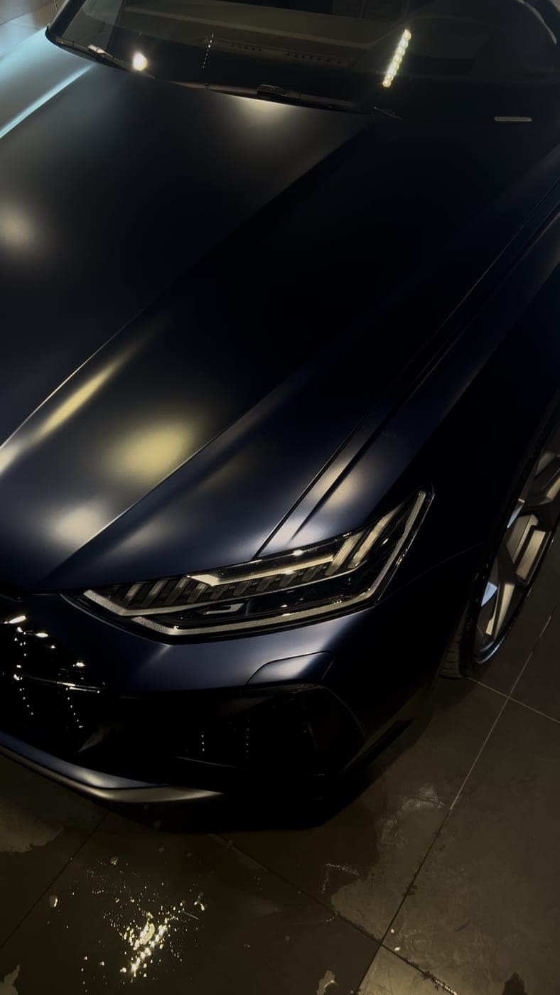 Audi RS6 in matte blue, front three-quarter view