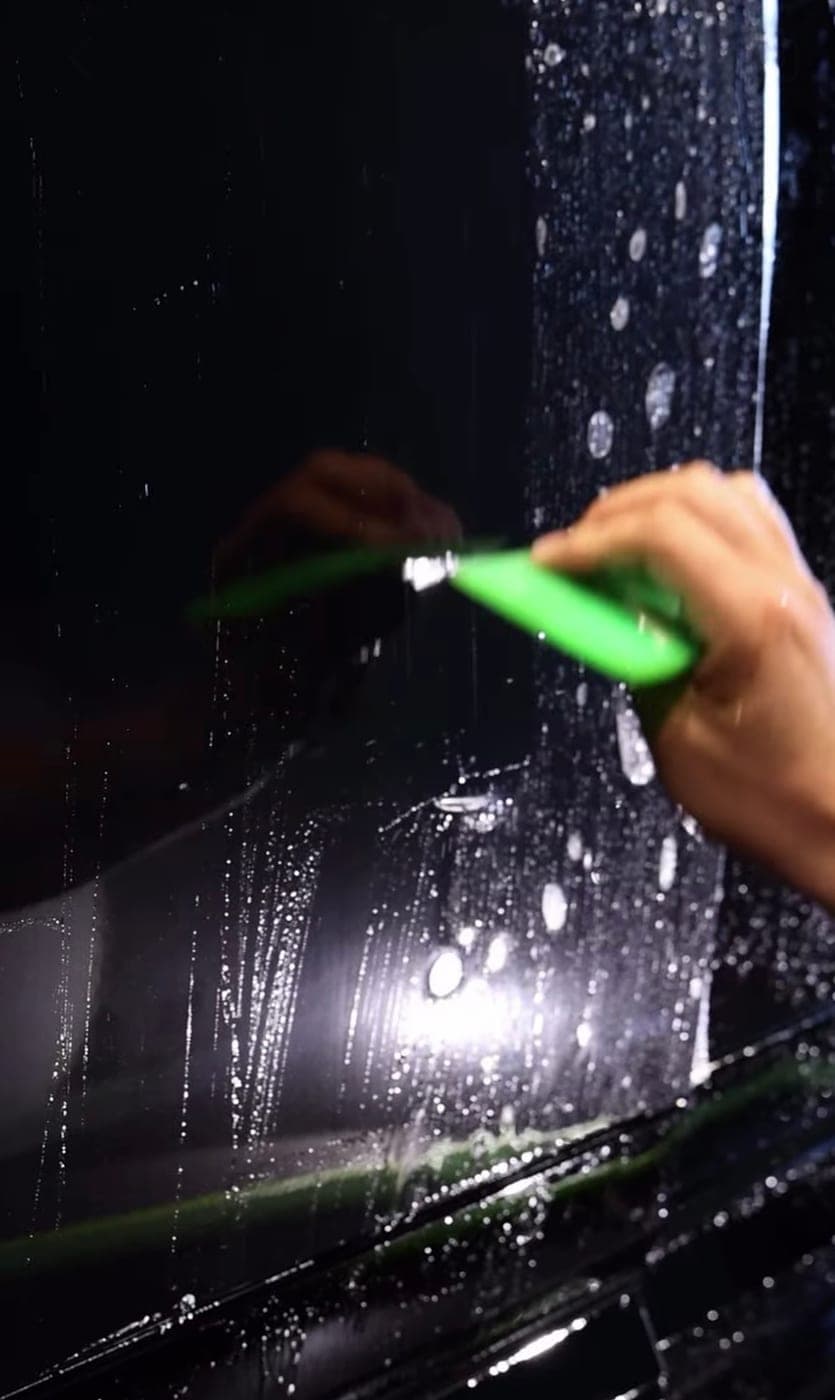 Squeegee pushing solution out from under protection film