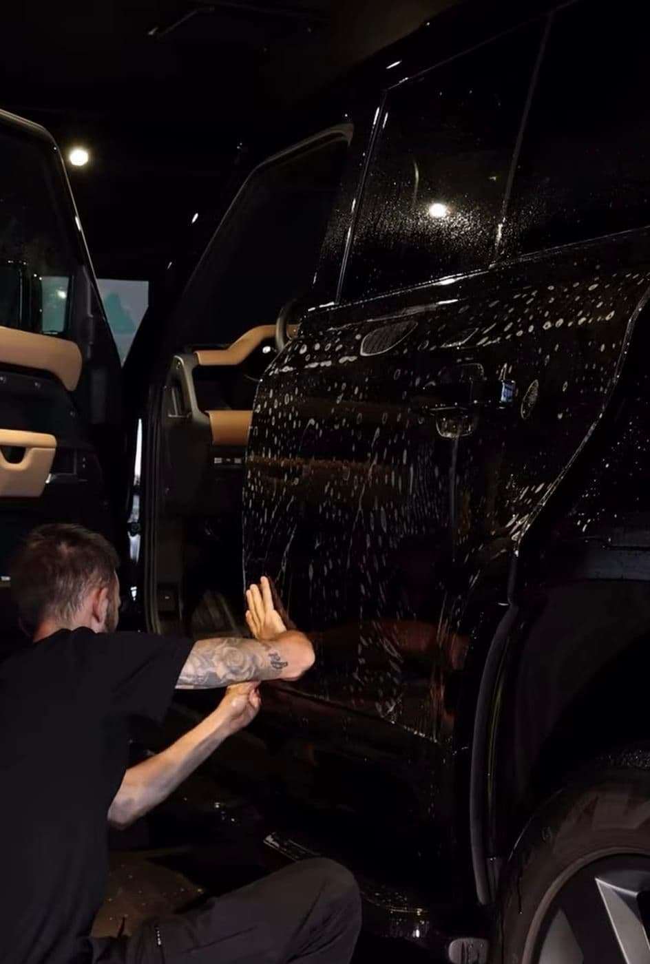 Protection film being laid onto a Land Rover Defender door